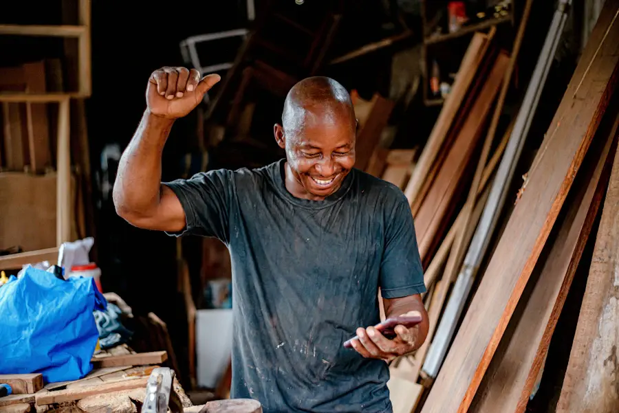 A carpenter celebrating as he reads his phone