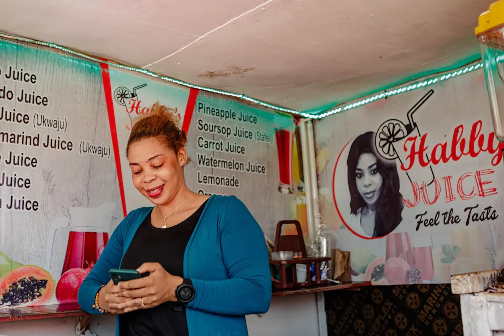 A juice bar owner checking her phone at her counter
